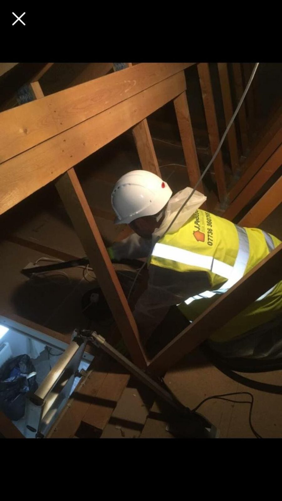 J Peacock fitter in full PPE bagging old loft insulation