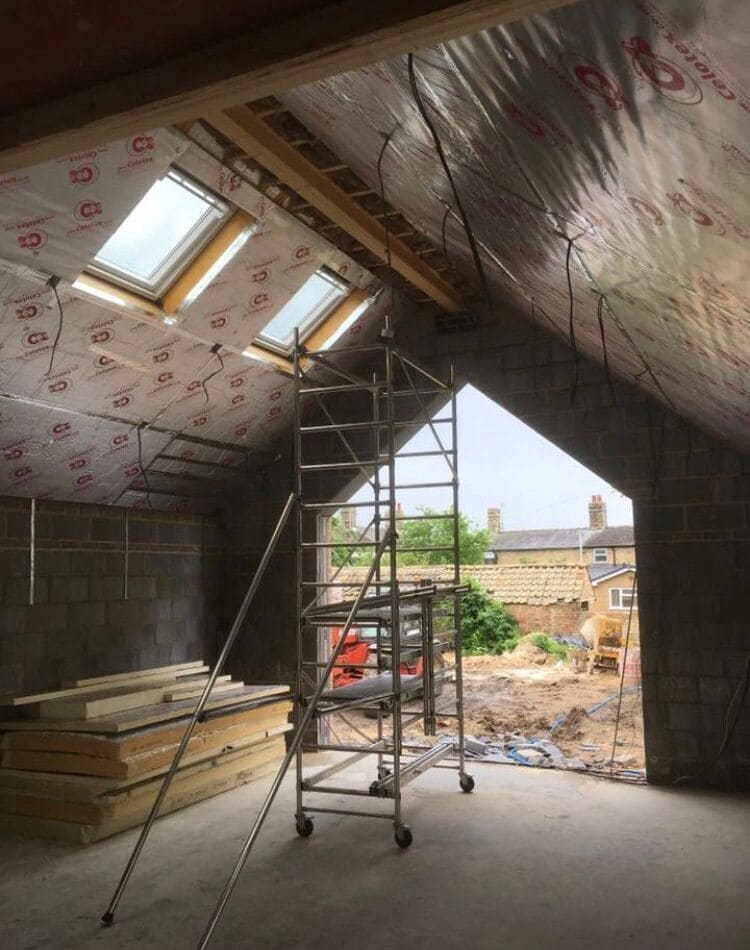 Foil-faced rigid board fitted across the rafters of a room in roof